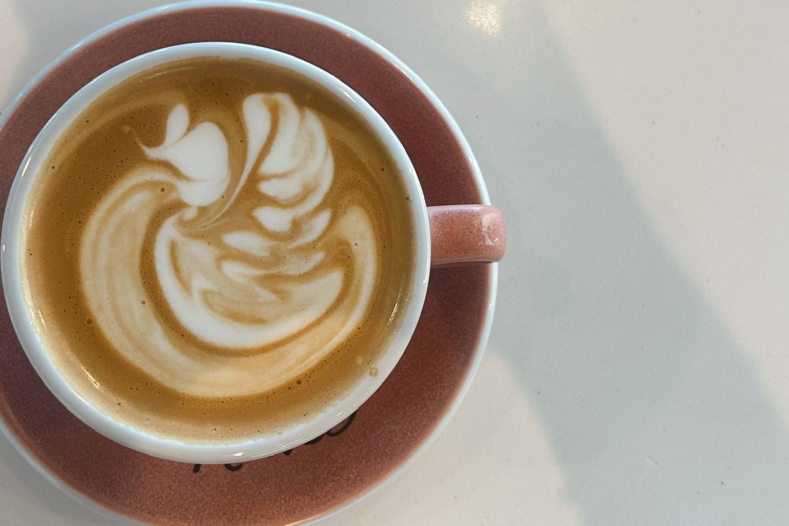 Latte art in a Jessie's branded cup and saucer